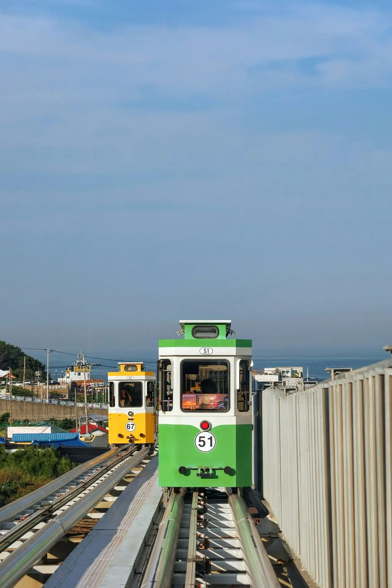 A green and white train traveling down train tracks